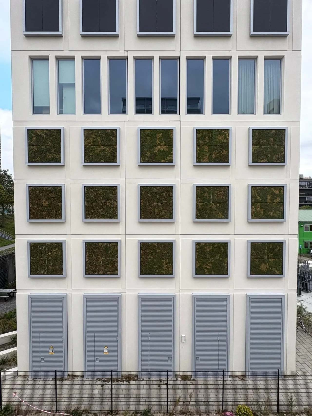 Residential building in Amsterdam with moss panels in gray frames on its facade