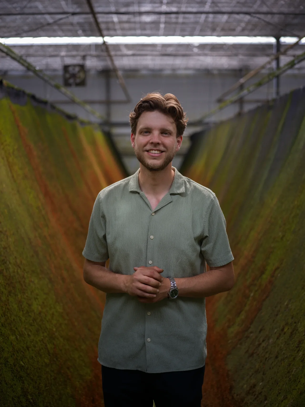 A Respyre team member between racks of growing moss mats